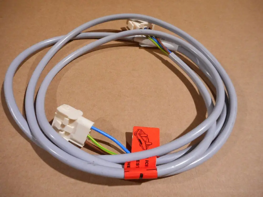 Remeha Kabel mit weißen Steckverbindern und mehreren farbigen Drähten, auf einem neutralen Hintergrund liegend.